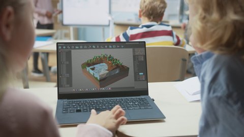 Elementary School Computer Science Classroom: Over the Shoulder View of Two Kids Using Laptop Computer to Design 3D Game, Building Level in Strategic Roleplaying Videogame