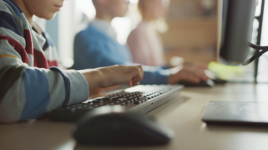 Elementary School Computer Science Classroom: Smart Little Schoolchildren Working Personal Computers, Typing on Keyboards, Using Computer Mouse. Schoolchildren Getting Modern Education. Focus on Hands - Powered by Shutterstock - Get 15% off with code: PIKWIZARD15