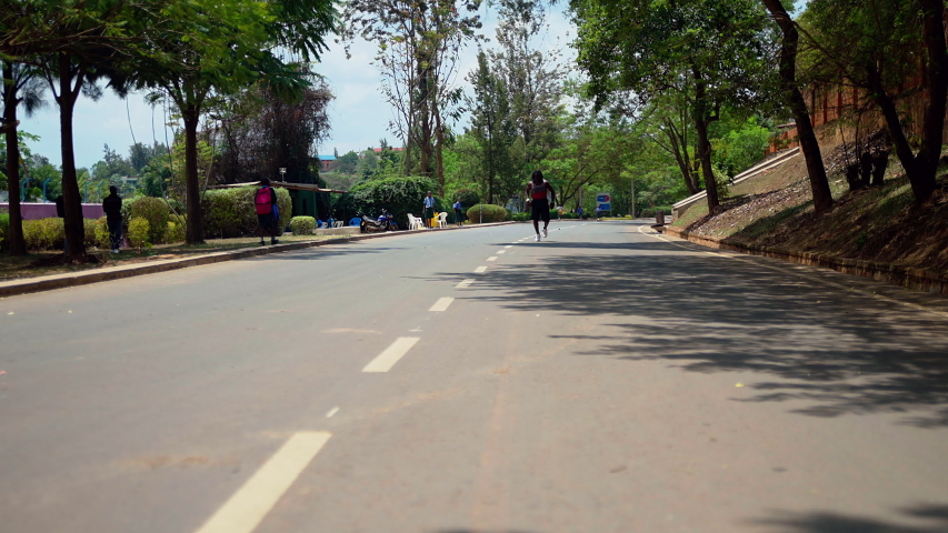 Free runner african man doing tricks at the  street training flips and speed running wide view shot