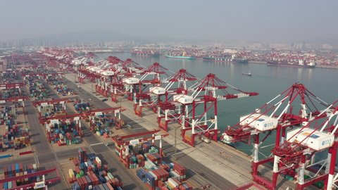 QINGDAO, CHINA – SEPTEMBER 2019: China shipping industry and port facilities - drone flight over container terminal in Qingdao