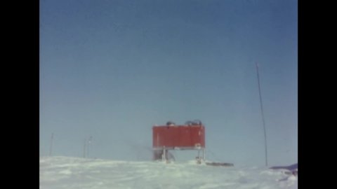 CIRCA 1957 - Dr. Paul Siple, scientific leader of the South Pole base, points out the base's ionosphere antenna, and how the equipment works.