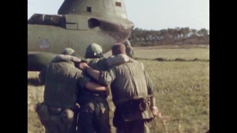 CIRCA 1967 - A CH-46 lands on a field in Vietnam. US Marine medics help wounded soldiers onto the helicopter.