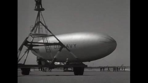 CIRCA 1945 - A portable mooring mast is moved away from a US Navy blimp, and the aircraft lifts off.