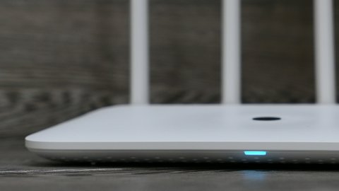 White Wireless Wi-Fi Router On The Grey Desk Panning Slider Shot.