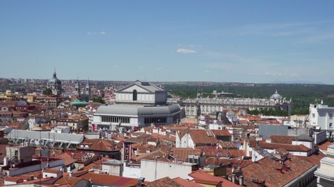Madrid / Spain - May 27 2019: view of the cathedral, the royal theatre and the royal palace in Madrid, Spain with surrounding traditional houses and rooftops, and a large park in the distance.