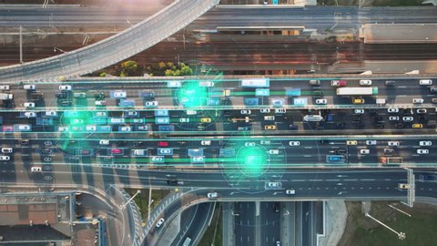 Beautiful aerial presentation of the autonomous cars self-driving concept on multi-level highway on the sunny evening in Moscow with 3 cars and their trajectories highlighted.
