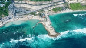 Melasti Beach in Bali. Indonesia. The shore of the Indian Ocean, video shooting from the air. Waves, azure water. Overview of the beach. Indonesia.