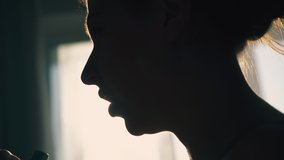 CU: dark silhouette of young woman using inhaler to relief asthma symptom against backlight in room extreme close view - Powered by Shutterstock - Get 15% off with code: PIKWIZARD15