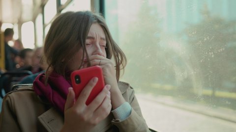 Young woman use phone sneezes coughs on the tram cold autumn day flu season disease fever grippe health illness infection influenza migraine sickness close up slow motion