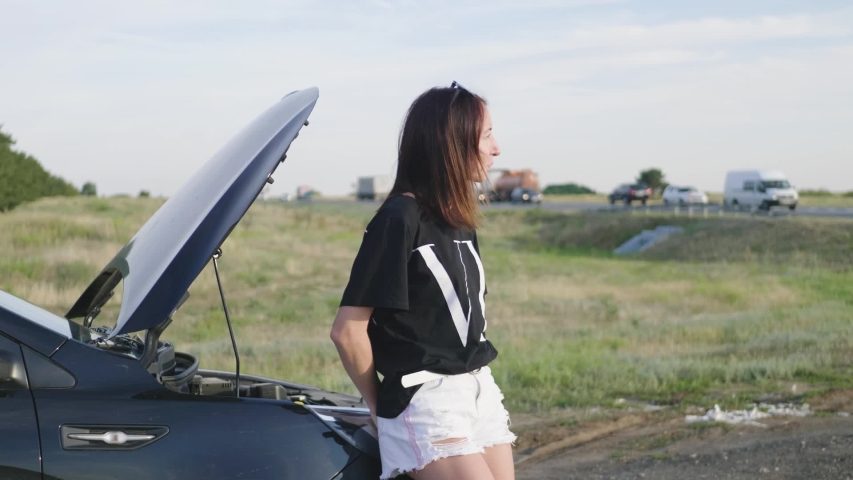 young girl with a broken car with open hood