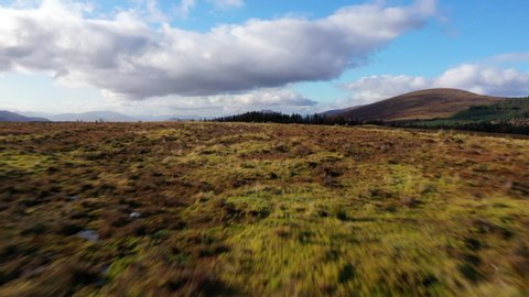 4K aerial drone footage fast and low over hill Scotland Highlands