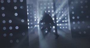 4K Professional Hip Hop , freestyle or swag dancer . Stylish young man dancing near decorative walls with many circle holes and spotlight . Real decoration . Shot on RED HELIUM Camera in Slow Motion .