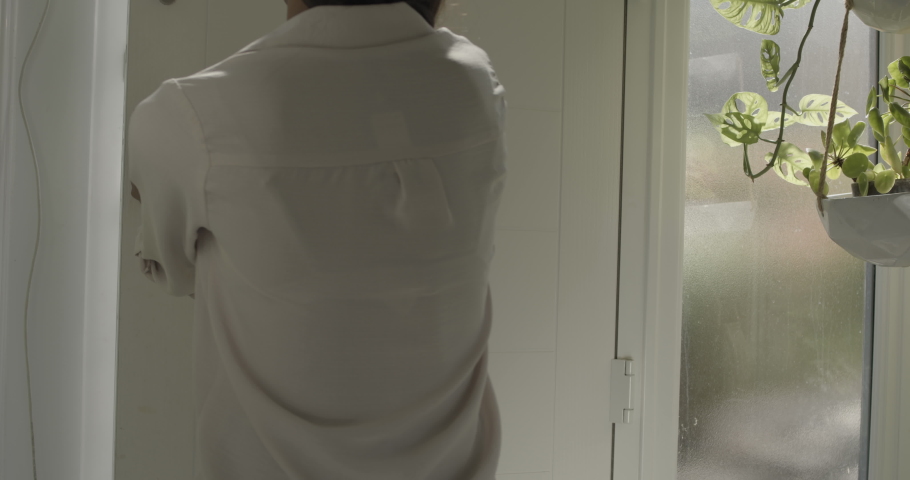 Female receiving package with vegetables at front door from delivery person