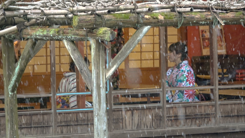 Tourists in traditional Kimono outfit at Kenrokuen Garden in snow in Kanazawa, Japan -Zoom Out-