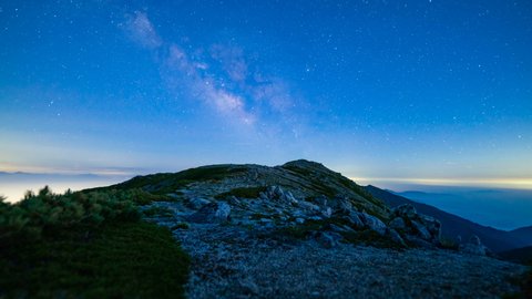 Astro timelapse tracking shot of Milky Way galaxy rising over Mt. Komagatake in Nagano prefecture, Japan