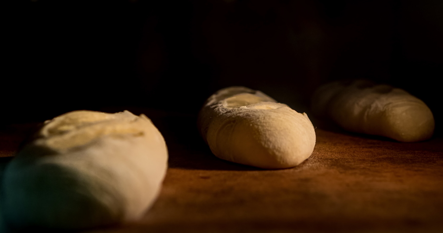 Warm fresh baguette in a bakery. Making bread and eco production. Manufacturing process working hard. Bakery shop and selling rooty. Baking Italian bio bread in oven. Time lapse footage of cooking. Royalty-Free Stock Footage #1040638487