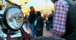 motorcycle front focus close up, with people in the background, day clip in 4k
