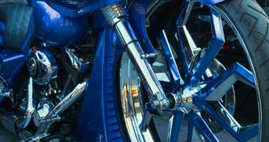Custom Motorcycle with chrome wheels, brake disc and blue front fender.  Metal lines, close up, day clip in 4k