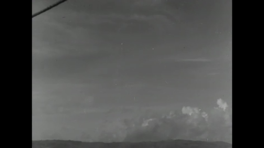 CIRCA 1944 - Soldiers fire automatic guns from a boat off the coast of Guam, during WWII.