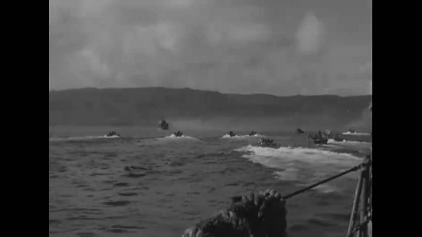 CIRCA 1944 - Warships and LVTs advance towards the beach during the Invasion of Guam in WWII.