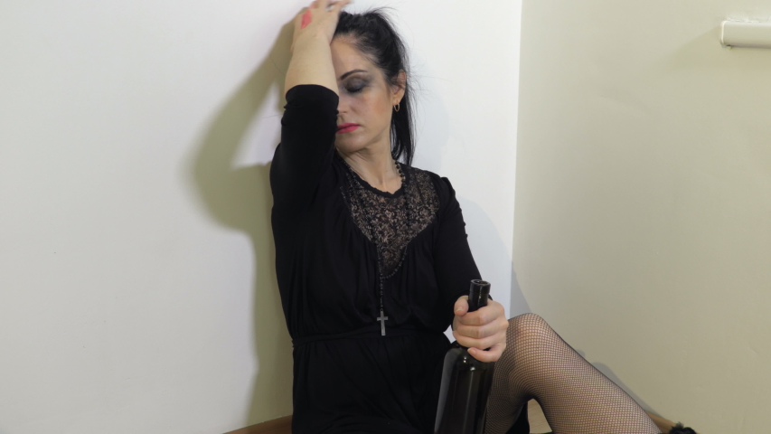 Sad, unhappy, helpless woman drinking alcohol