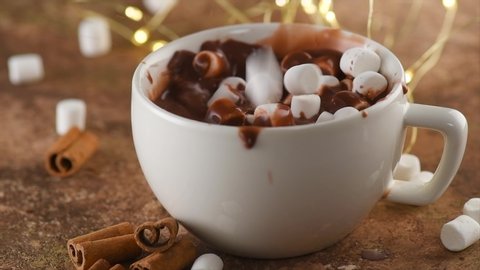 Hot Chocolate with Marshmallow. Falling marshmallows in a Cup of Hot beverage closeup. Concept of winter time, fall, Christmas holidays. 4K UHD video, slow motion