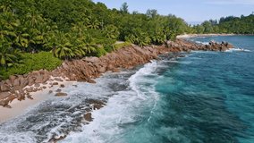 Aerial 4K drone view of rocky tropical coastline with ocean waves at Mahe island, Seychelles