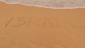 Tel Aviv beach. Israel.  inscription on the sand israel. Guy run on the beach - video