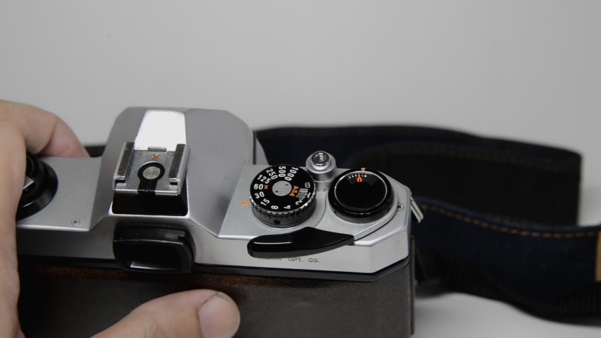 Vintage film camera ISO adjustment dial turned by hand