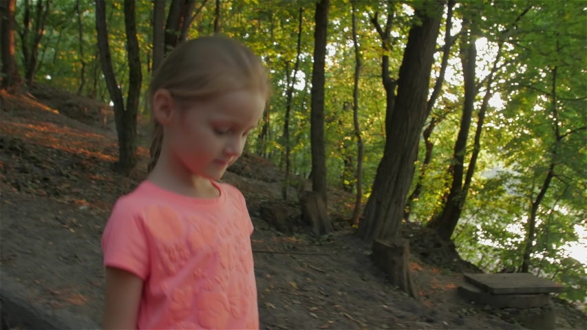 Little Girl Looks Around In Forest
