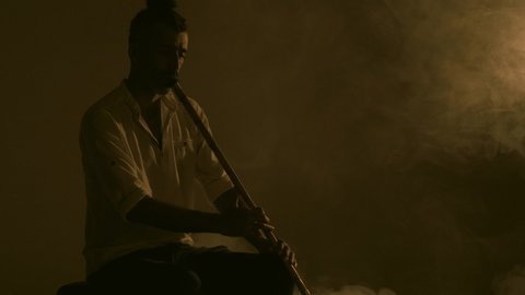 Middle Eastern man Playing a Flute in smoke.