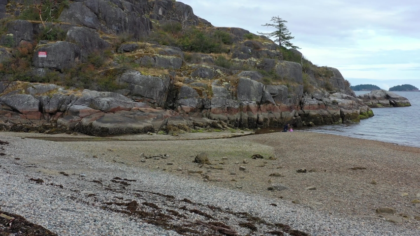 Aerial view over inlet, ocean and island with boat and mountains in beautiful British Columbia. Canada. 4K.