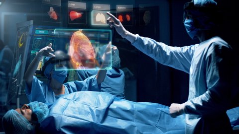 Group of surgeons using augmented reality holographic holo lens headsets interacting with a virtual interface showing patient organs. Doctor analyses LUNGS. Shot on RED Epic W Helium 8K Cinema Camera.