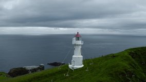 Aerial drone video flying over old lighthouse on the Mykines island, Faroe islands, Denmark. UHD 4k video