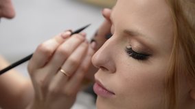 makeup artist does makeup to a beautiful girl