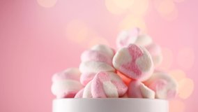 Marshmallow. Close-up of Marshmallows colorful chewy candy, rotation over pink background. Sweet food dessert in a cup with hot chocolate close-up. 4K UHD video 