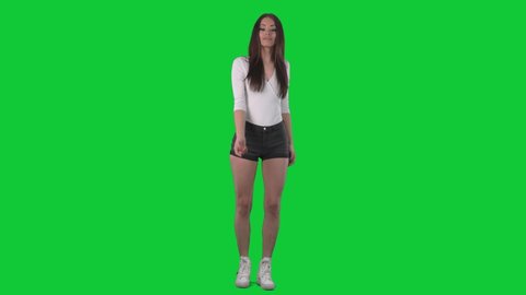 Sexy young woman in casual summer clothes inviting and beckoning you with finger to join. Full body over green screen background. 
