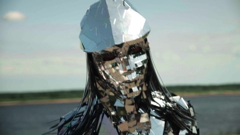 Close-up shot of a dancing woman in a shiny disco robot costume made of mirrors 
