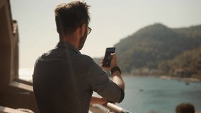Man Taking Photo On Vacation In Resort. Man Takes Pictures On Smartphone On Seashore. Male Taking Self Photo And Answer To Video Call On Sea Cliff. Man Take Photo On Beautiful Place In Turkey Coast