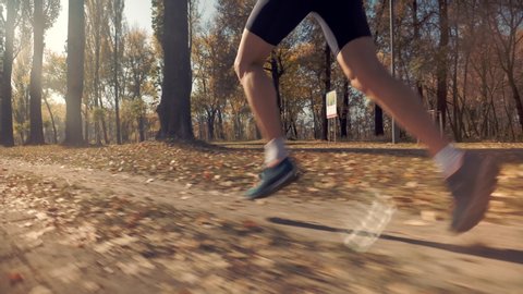 Triathlete Running,Sprinting And Endurance Workout Training.Marathon Runner Jog On Park.Running Man In Forest At Sunset.Runner Man Fit Athlete Legs Jogging On Trail Ready To Triathlon.Sport Concept.