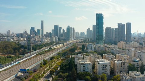 Aerial flight toward tel aviv and ramat gan skyline with urban skyscrapers and cars driving on the highway, Israel