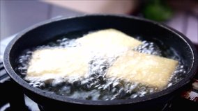Handheld video shot of fofu or tokwa or soy bean curd being fried in a pan