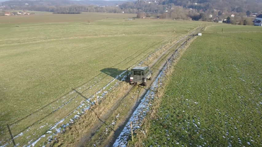 Car driving on a road between fields