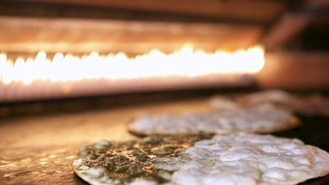 Making Manakeesh inside a gas heated oven, slow motion. Manakeesh is a type of pastry, which is a popular Lebanese and Levantine food consisting of dough topped with thyme, cheese or meat
