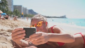 Young woman taking a selfie on Waikiki beach in Honolulu, Hawaii 