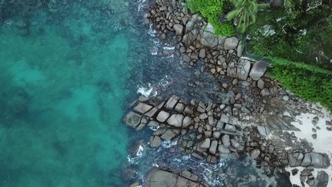 aerial footage of sea shore and mountains. ocean, waves and palms view. rocks by water of Indian ocean. Seychelles
