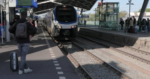 S-Hertogenbosch, THE NETHERLANDS - SEPTEMBER 14, 2019: Train arriving at a station and passengers boarding. The state run railway company NS operates the third busiest rail network in the world