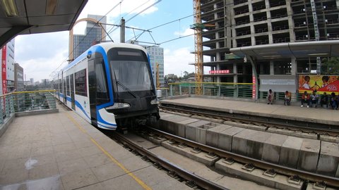ADDIS ABABA – MARCH 2019: Wide angle view of modern light rail train (metro) arriving at station platform in central Addis Ababa, Ethiopia