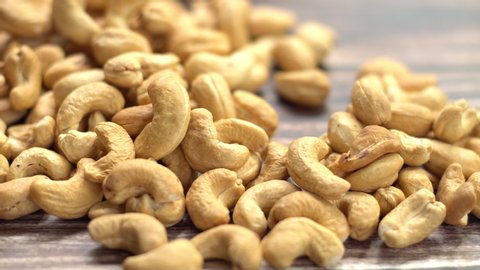 Still life of toasted cashew nuts on table, selective focus and movement camera, free space for text. Good healthy food ideas concept.