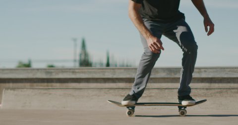 Skateboarder skateboarding in slow motion doing an ollie kickflip in a skatepark with super clean style